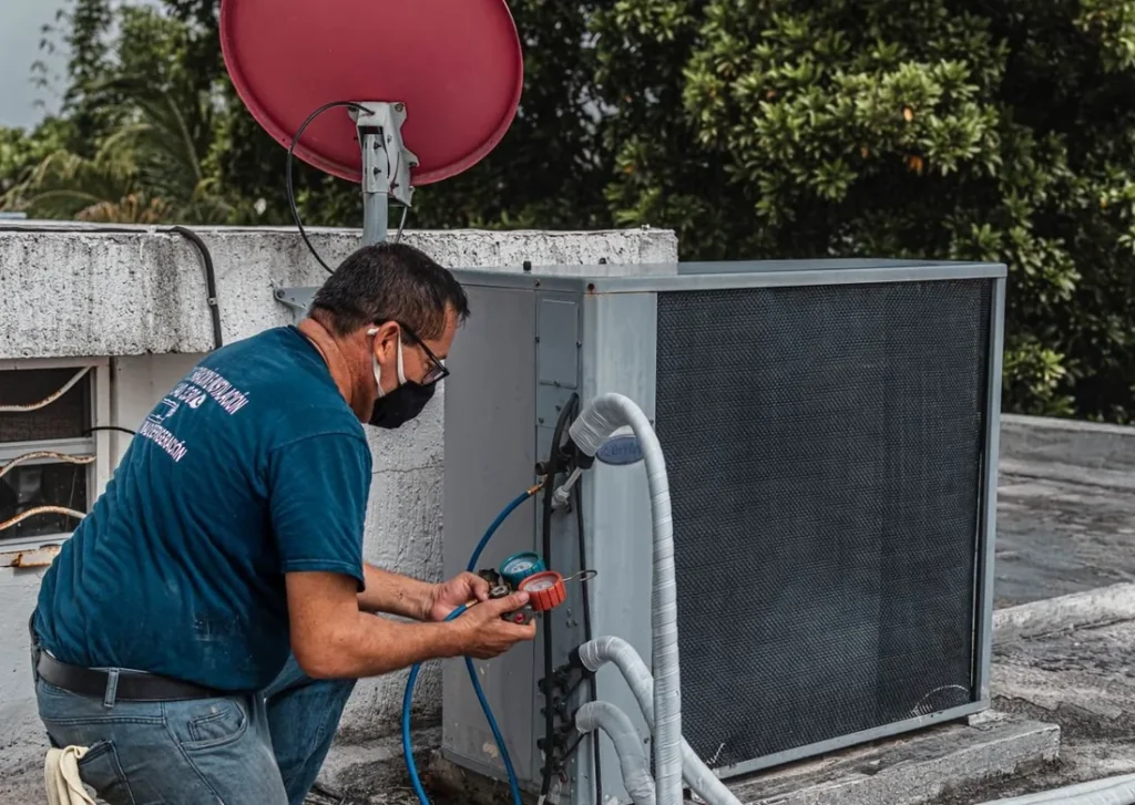Técnico revisando um ar-condicionado split durante manutenção preventiva