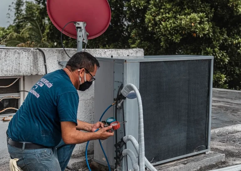Técnico revisando um ar-condicionado split durante manutenção preventiva